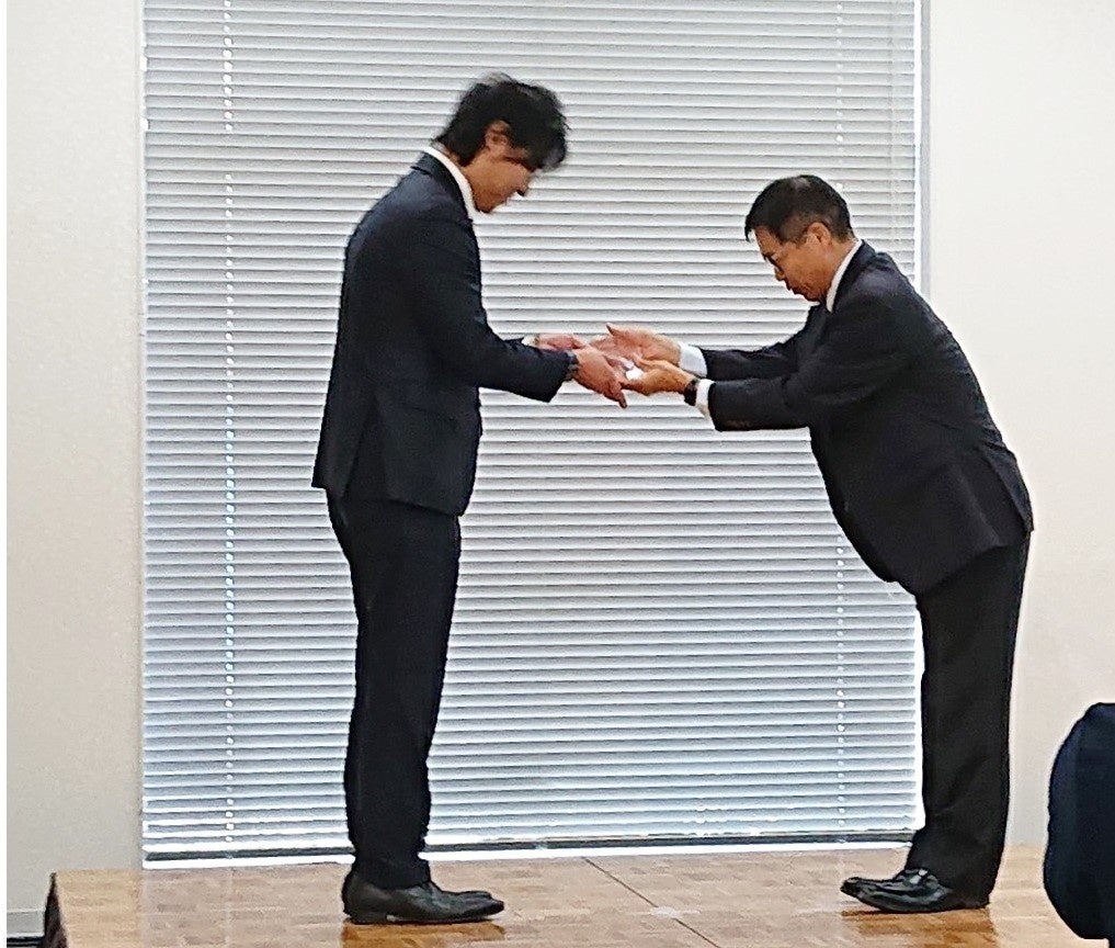 北理事長に表彰盾を授与する佐藤本部長・URA（右）