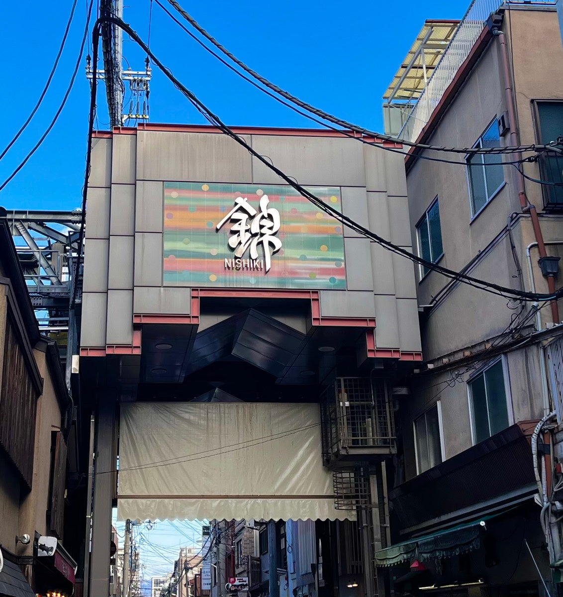 京の台所、400年の歴史 錦市場は京都市内の目抜き通り「四条通り」の１本北に位置し、錦小路通の寺町から高倉まで東西390メートルにもなる「京の台所」と言われる「商店街」です。400年の歴史を持ち、京都市民からは「にしき」という愛称で呼び親しまれています。