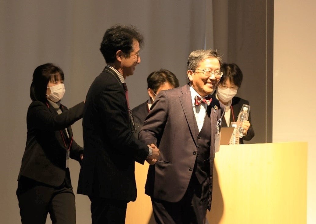 講演を交代する際に握手を交わす那須学長と田村部長