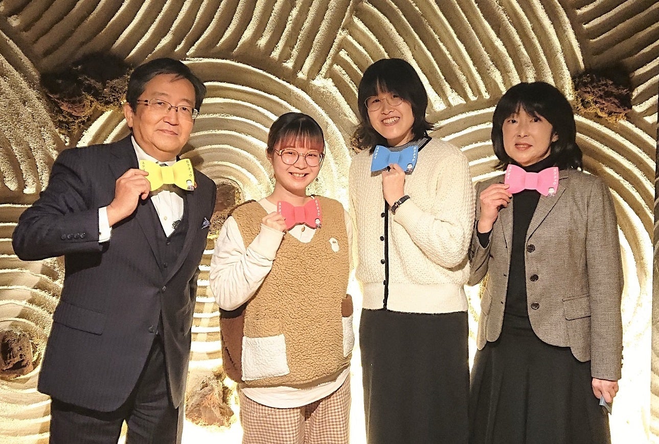 那須学長の蝶ネクタイをモチーフにした「ガクチョウネクタイ」を手にしての記念撮影（左から那須学長、土井さん、中村さん、三村理事）